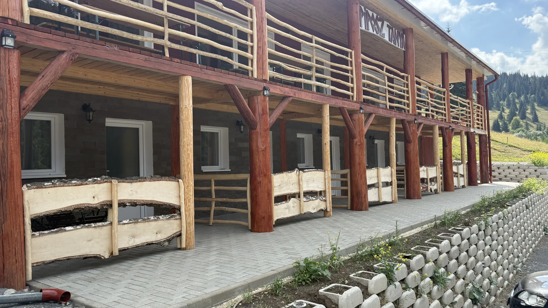 Az Apartmanok kétszintes fa tornáca és bejáratai